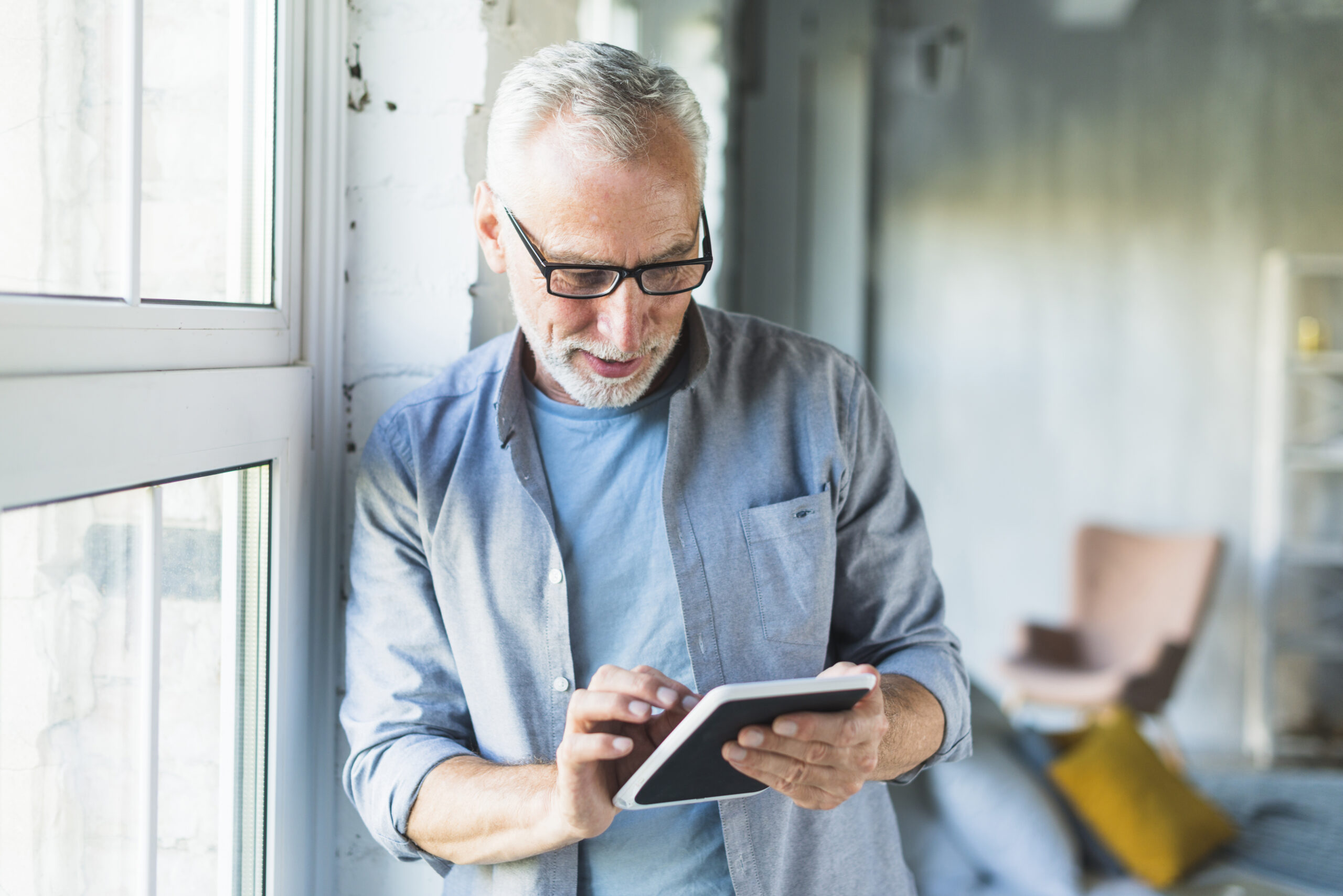 portrait-senior-man-using-digital-tablet portrait senior man using digital tablet scaled